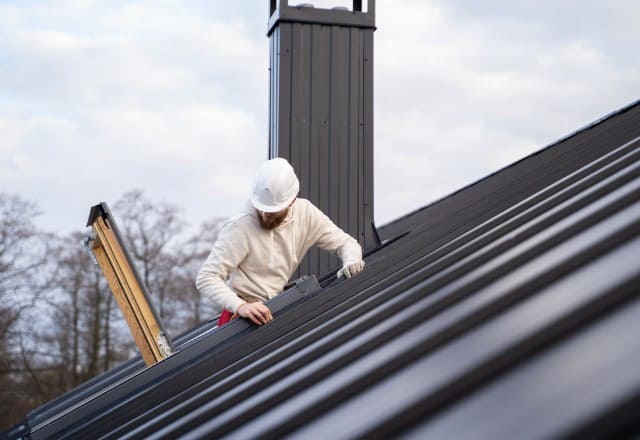A contractor measuring a roof before beginning the installation process