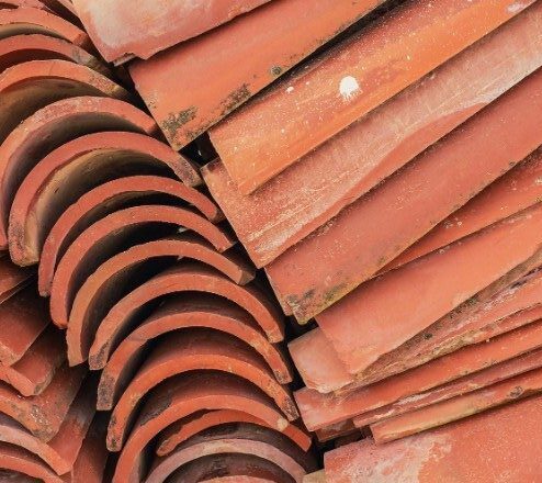 Close-up of stacked red roof tiles, illustrating the type of covering material used in flashing repair for roof maintenance
