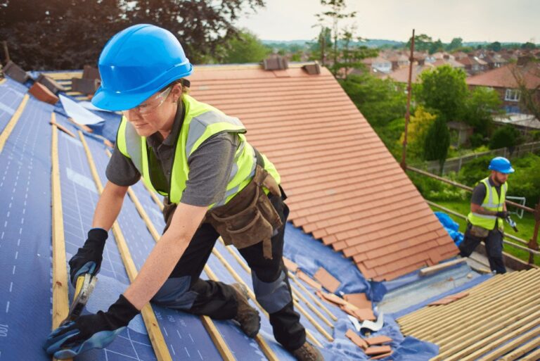 Female roofer fixing the roof underlayment