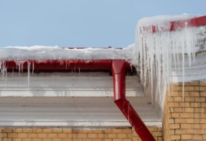 Icicles hanging from the eaves as evidence of an existing or forming ice dam on the roof above them.