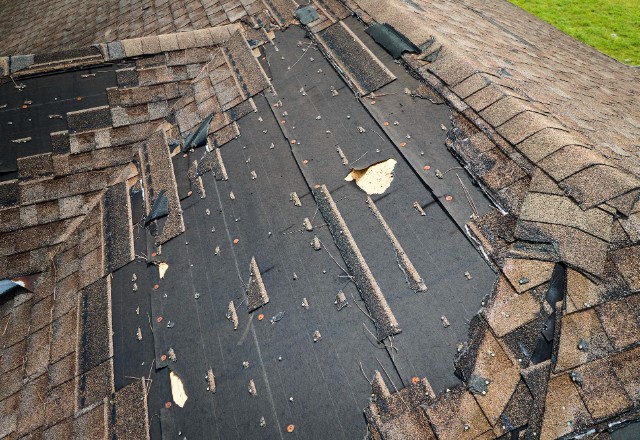 An experienced roofer inspecting a roof for damage and leaks.