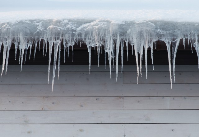 Icicles hanging from the eaves as evidence of an existing or forming ice dam on the
roof above them.