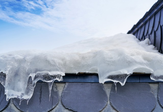 The exterior wall of a house, showing snow melting from a localized area due to an ice
dam.