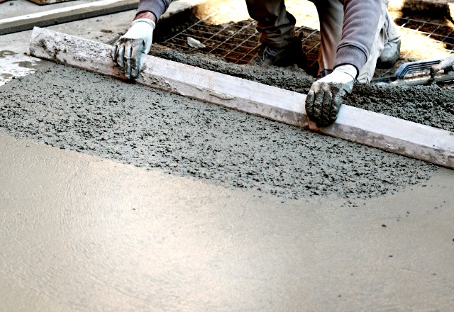 An image showcasing expert guidance for cold weather concrete placement, depicting a worker skillfully leveling concrete in a low temp setting