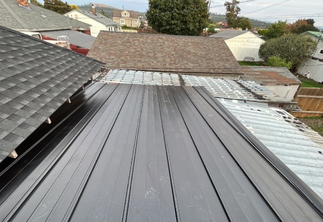 A new, shiny metal roof installed on a modern home in Spokane, WA, showcasing the skilled craftsmanship of local metal roofers