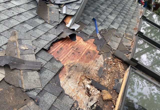 Severely damaged shingles and exposed roof decking, highlighting the urgent need for repair by expert roofers near me in Spokane