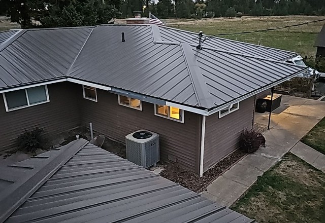 Newly installed sleek metal roofing on a residential house in Spokane, WA, enhancing the property's durability and aesthetic appeal.