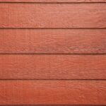 Richly textured wooden wall with a deep red siding color, exemplifying quality wood siding available in Spokane.