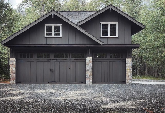 Modern dark grey garage built by expert garage builders in Spokane, featuring stone accents and dual doors for spacious access