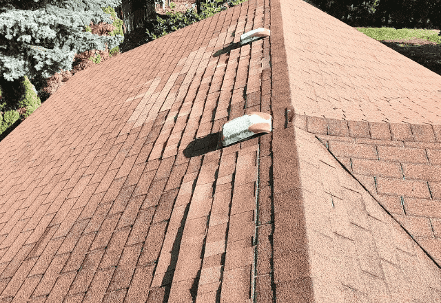 Roof repair Rathdrum - image of a residential shingled roof with two vent pipes in need of repair