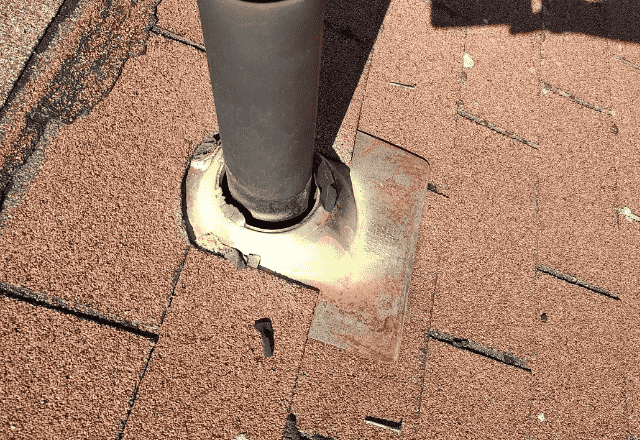 Roof repair Rathdrum - close-up of a deteriorating roof vent boot with visible damage and wear on the surrounding shingles