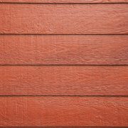 Richly textured wooden wall with a deep red siding color, exemplifying quality wood siding available in Spokane.